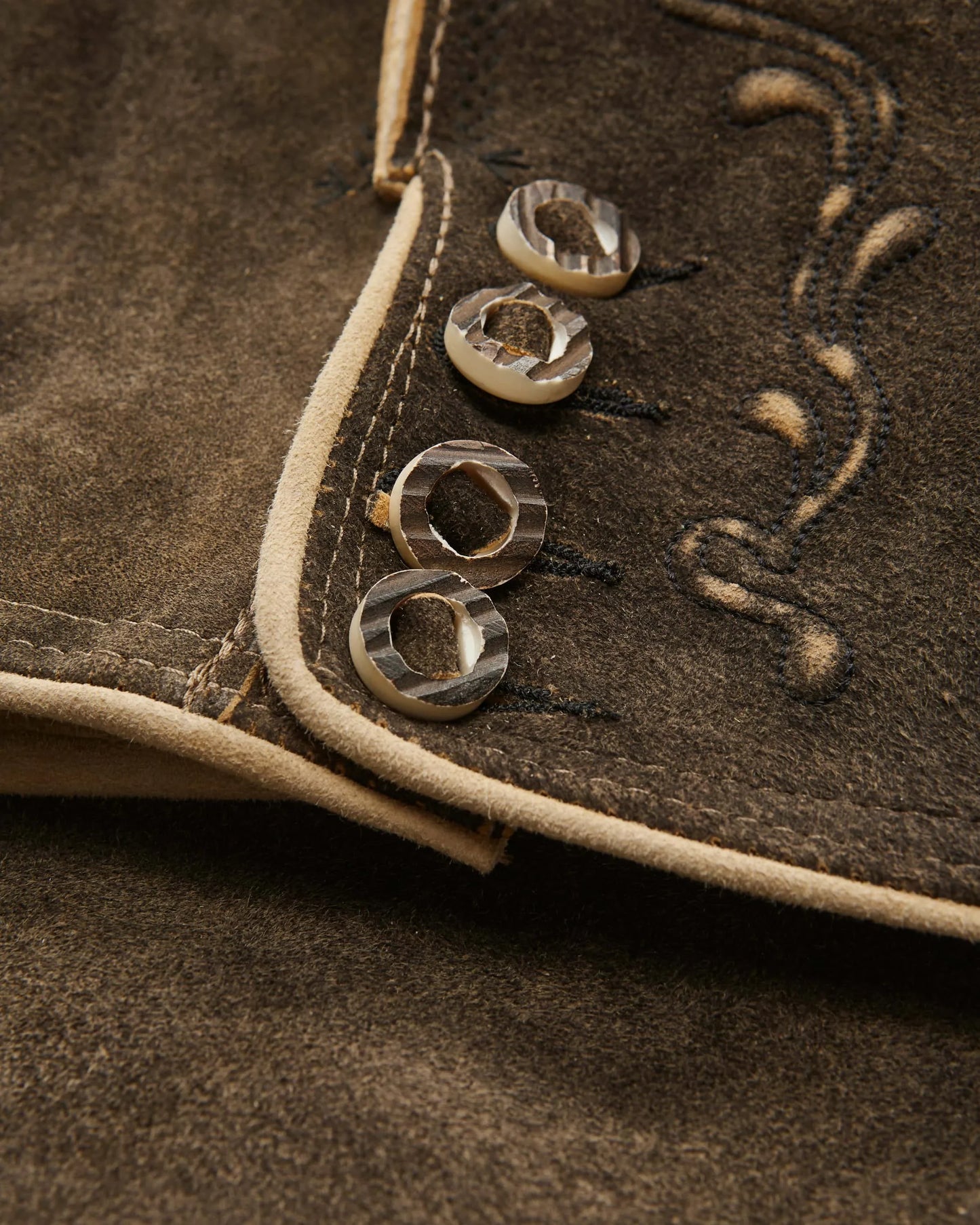Close-up of brown leather with decorative stitching