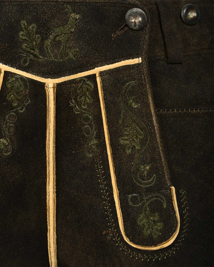 Close-up of dark fabric with embroidered patterns and buttons