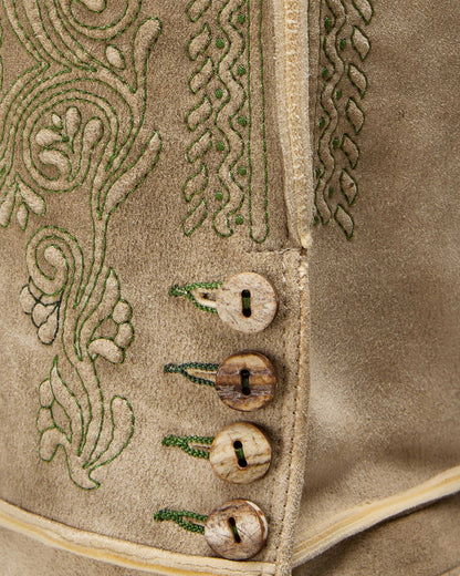 Close-up of a textured fabric with embroidered patterns and buttons.