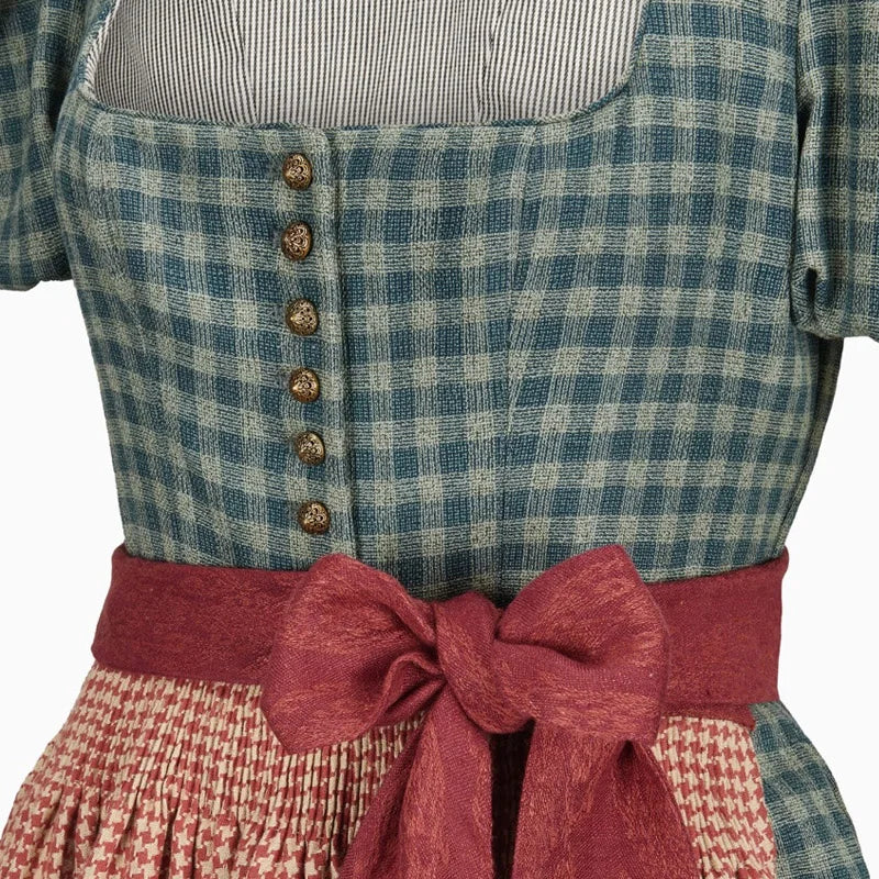 Close-up of a person wearing a blue and green checkered top with a red belt and plaid skirt.