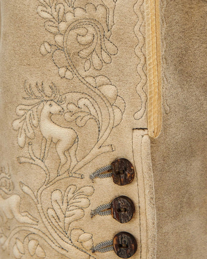 Close-up of a textured surface with intricate designs and buttons on a beige background