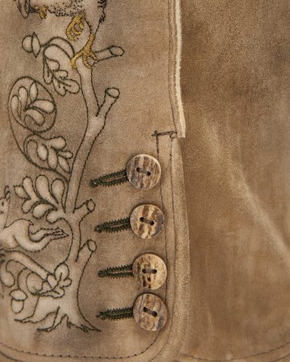 Close-up of a brown leather vest with embroidered design and buttons.