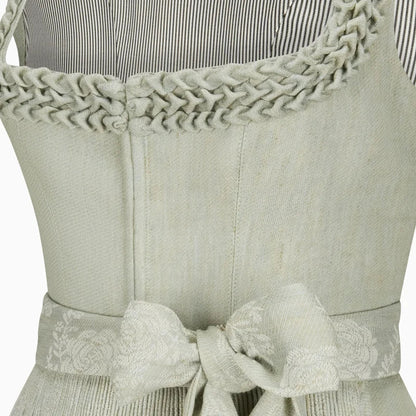 Light green apron with braided trim and a bow detail on a white background