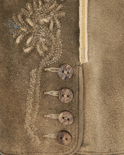 Close-up of a textured fabric with embroidered details and buttons.