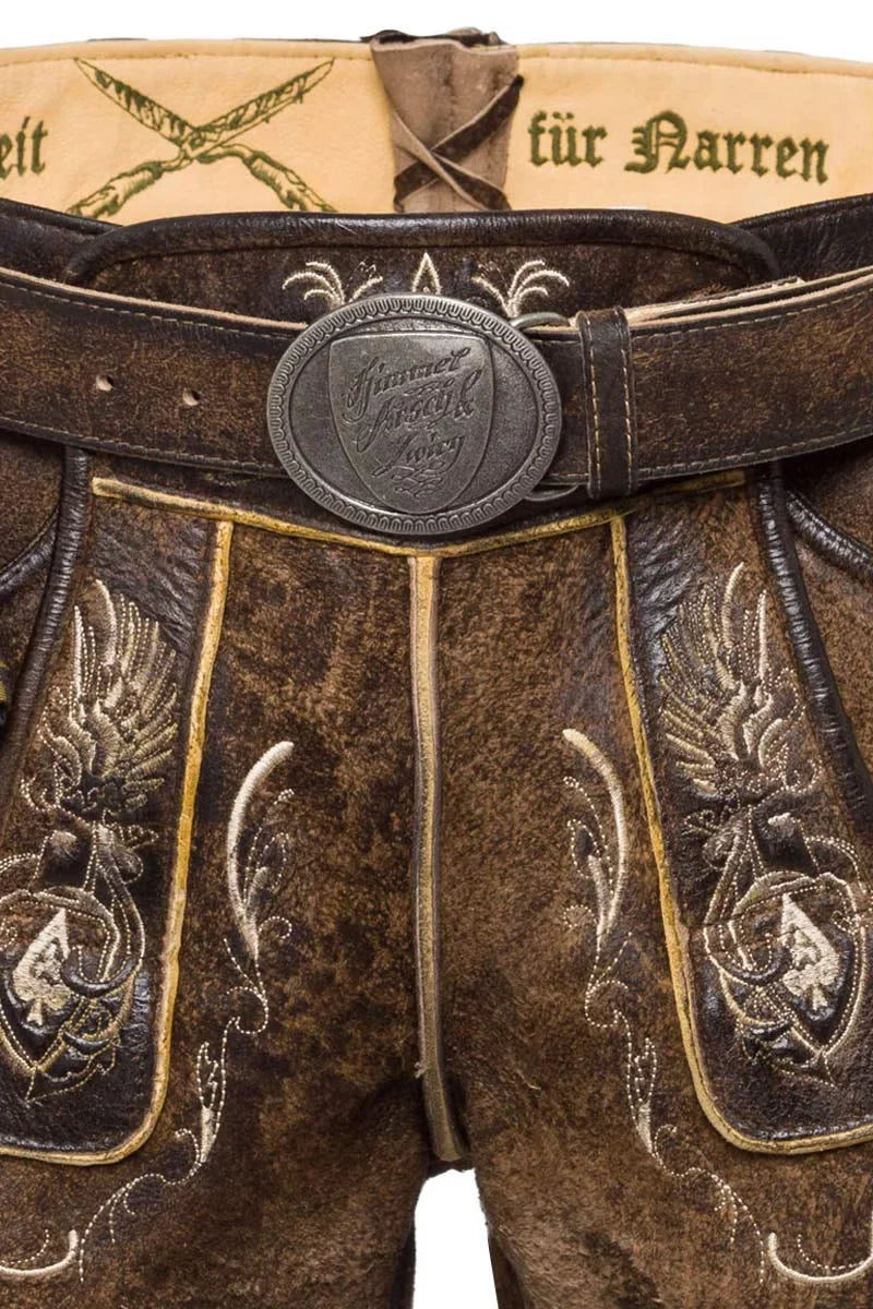 Brown leather pants with intricate embroidery and a belt buckle, featuring German text.
