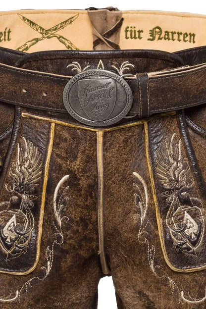 Brown leather pants with intricate embroidery and a belt buckle, featuring German text.