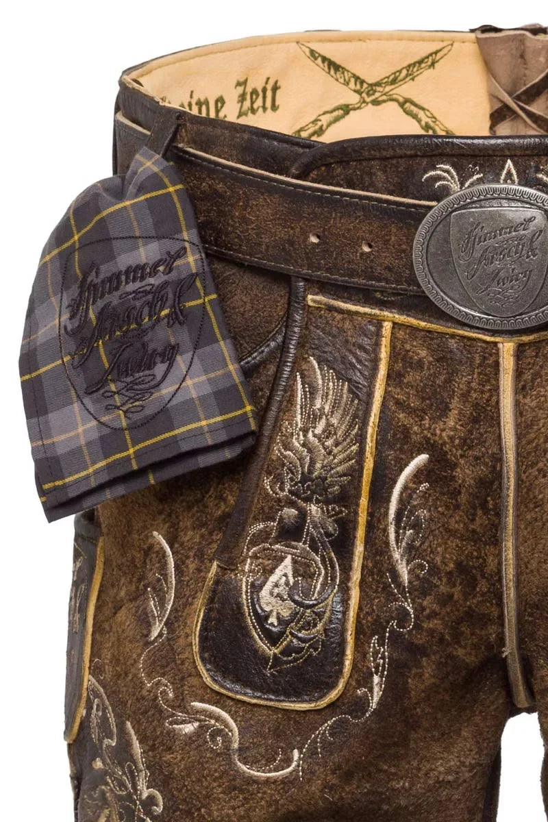 Close-up of a traditional brown leather outfit with intricate designs and a tartan pocket square.