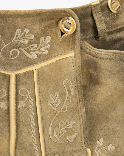 Close-up of brown fabric with embroidered floral patterns and button details.
