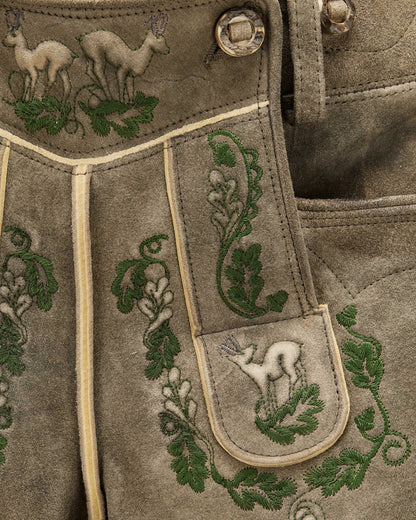 Embroidered fabric with deer and leaf patterns on a brown background
