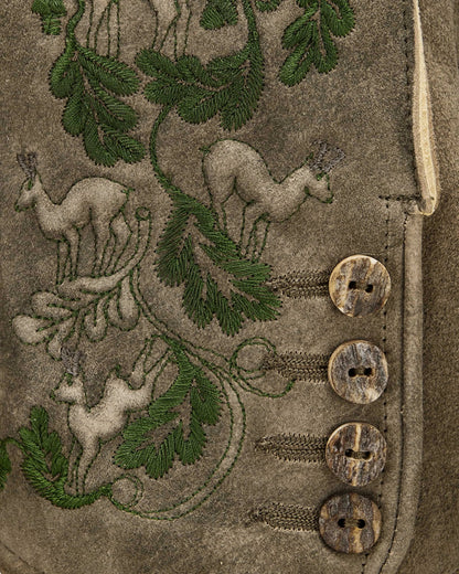 Embroidered design on a fabric with deer and leaves, featuring buttons.