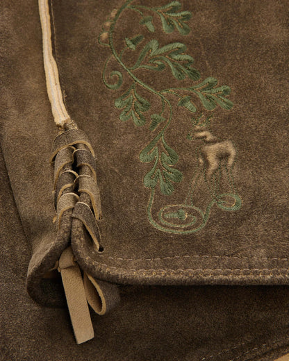 Brown leather bag with embroidered design of a nude figure and foliage.