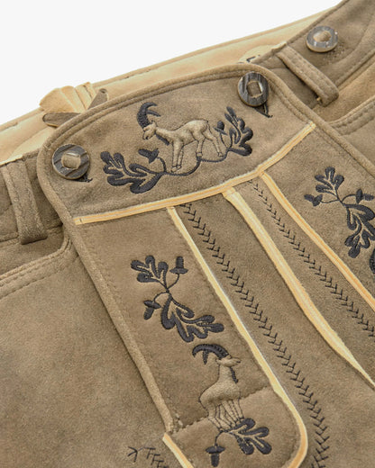 Close-up of a beige fabric with embroidered designs on a white background