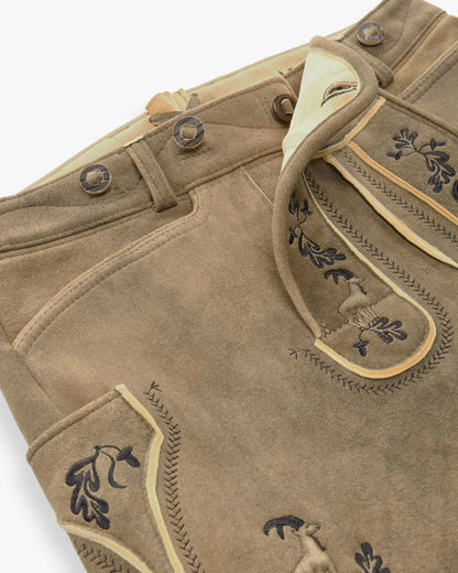 Close-up of brown leather pants with decorative stitching and buttons on a white background