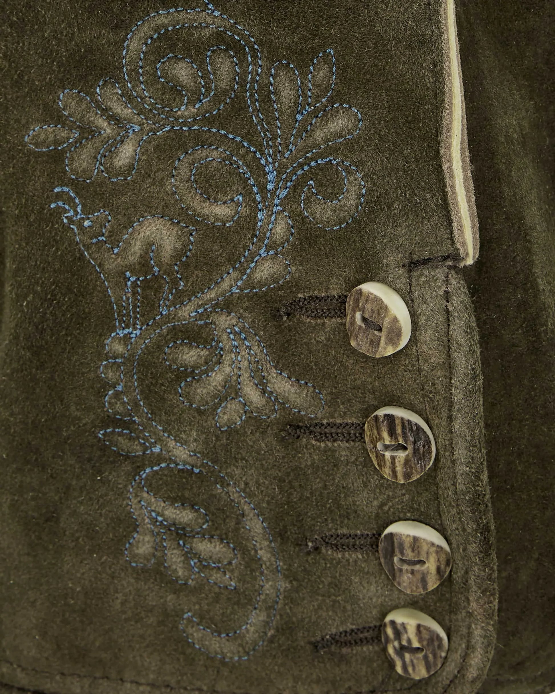 Close-up of a brown suede jacket with intricate floral embroidery and decorative buttons.