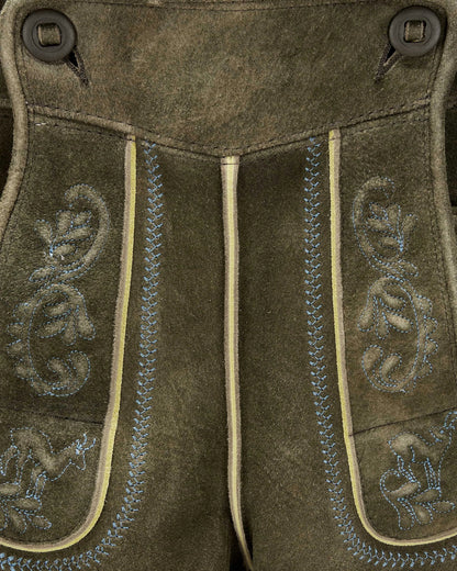 Close-up of brown leather pants with decorative stitching and patterns.