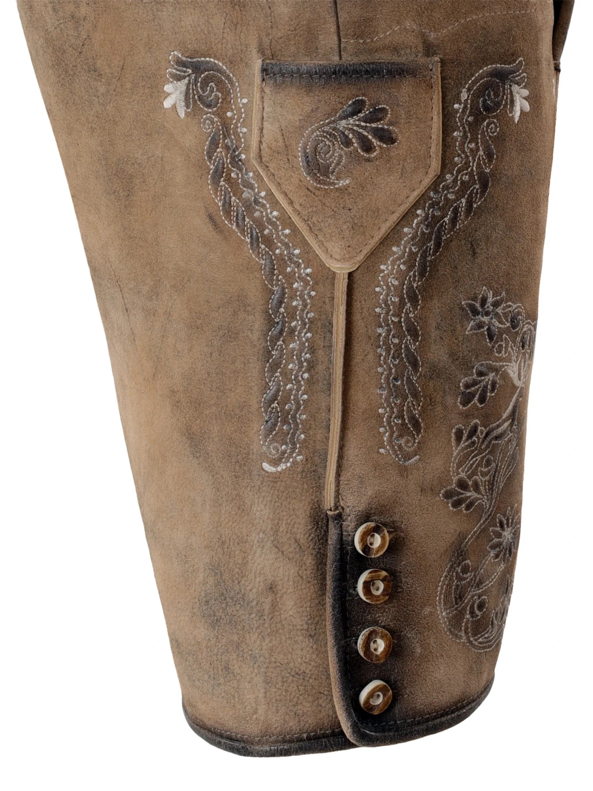 Close-up of brown leather pants with intricate embroidery and button details on a white background