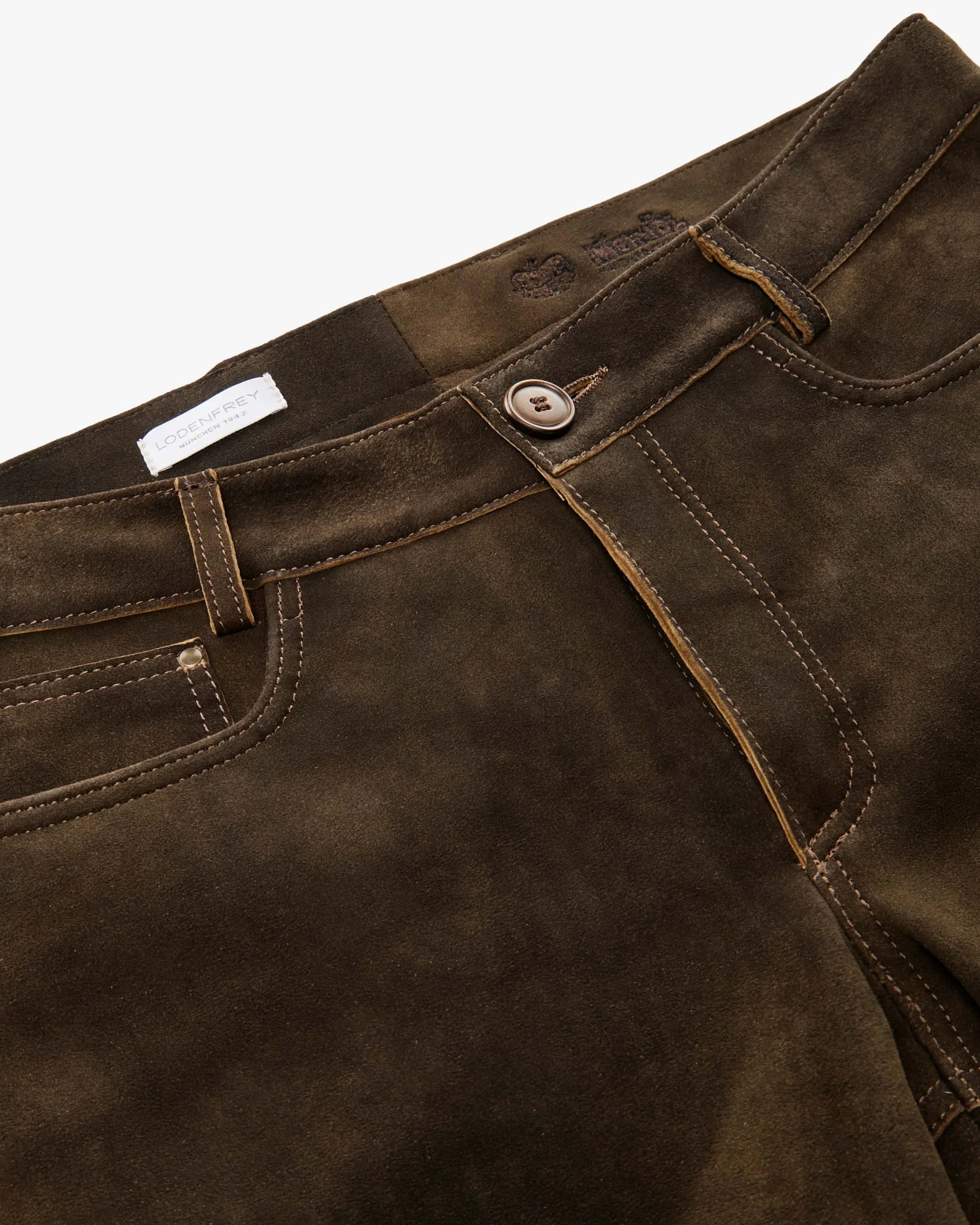 Close-up of dark brown leather pants with a button and stitching detail on a white background.