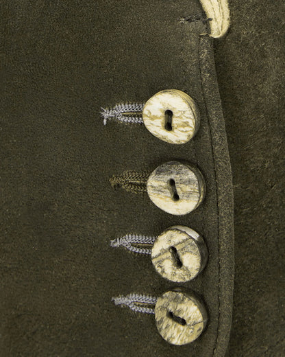 Close-up of a leather boot with metal buttons and laces on a dark background