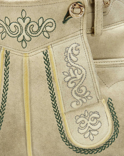Close-up of beige traditional embroidered pants with green and white patterns.
