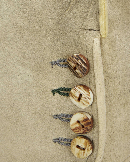 Three wooden buttons with leaves on a beige fabric background